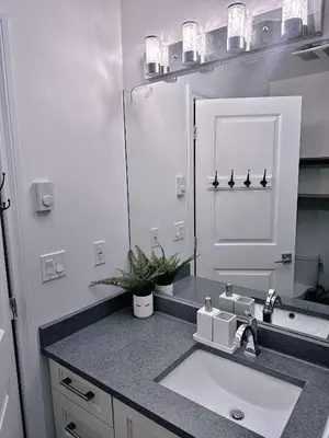 a bathroom with a sink and a mirror at The warm and lovely coach home in Vancouver
