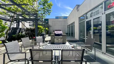 a patio with chairs and a table on a building at Stunning 1-Bedroom Condo in the Heart of Vancouver in Vancouver