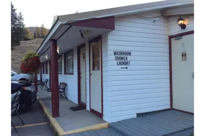 a white building with a sign that reads visitor service library at Victorian Motel & RV Park by Capital O in Grand Forks