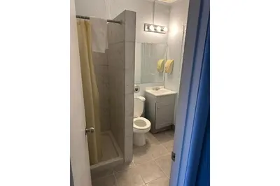 a bathroom with a toilet and a shower at Victorian Motel & RV Park by Capital O in Grand Forks