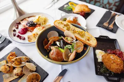 a table with a plate of food and a bowl of food at Oysterbeds offers our Oyster Suite in Lund