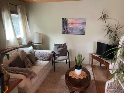 a living room with a couch and a chair at Oysterbeds offers our Oyster Suite in Lund