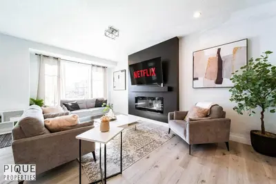 a living room with a couch and a table at Modern Retreat - 3 King Beds - Garage - WiFi - Sleeps 10 in Edmonton