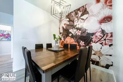 a dining room table with a flower mural on the wall at Modern Retreat - 3 King Beds - Garage - WiFi - Sleeps 10 in Edmonton
