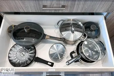 a tray with a bunch of pots and pans at Modern Retreat - 3 King Beds - Garage - WiFi - Sleeps 10 in Edmonton