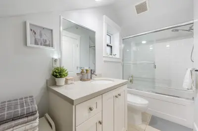 a white bathroom with a sink and a toilet at Cozy and Modern 2br guesthouse in Vancouver
