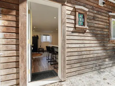 a sliding door leading to a dining room with a table at Fairfield Estate Coach House - 30-Day Stay, steps from Cook Street Village by Victoria Prime! in Victoria