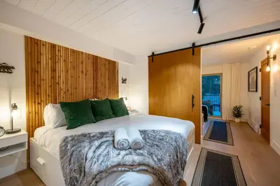 a bedroom with a large white bed with green pillows at Powder & Pines Boutique Apartment in Whistler