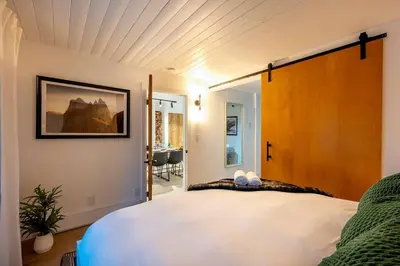 a bedroom with a large white bed in a room at Powder & Pines Boutique Apartment in Whistler