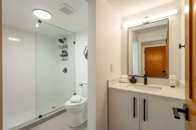 a bathroom with a toilet and a sink and a shower at Powder & Pines Boutique Apartment in Whistler