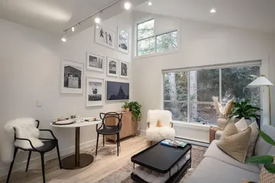 a living room with a couch and a table and chairs at Skywood-Designer Condo,Steps to Creekside Gondola, Free Parking in Whistler