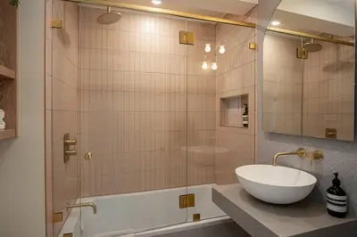 a bathroom with a sink and a shower with a tub at Skywood-Designer Condo,Steps to Creekside Gondola, Free Parking in Whistler