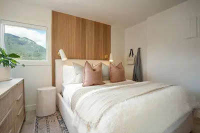 a bedroom with a white bed with pillows and a window at Skywood-Designer Condo,Steps to Creekside Gondola, Free Parking in Whistler
