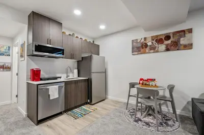 a kitchen with a small table and a refrigerator at Perfect Stay 2 Bedroom Basement Suite in Airdrie