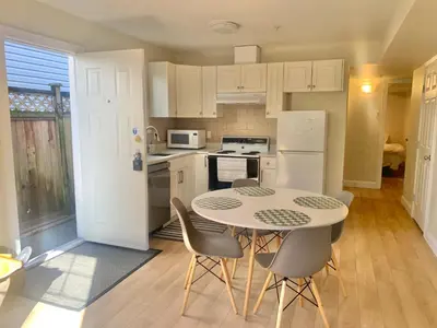 a kitchen with a table and chairs and a refrigerator at Entire 1Bed 1Bath Suite Coquitlam Centre in Port Coquitlam
