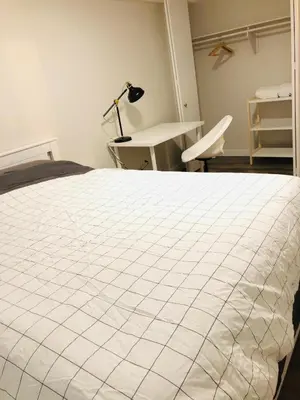 a bedroom with a bed and a desk and a lamp at 5th Floor 1 Bedroom Condo with Parking in Calgary