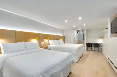 two beds in a hotel room with white sheets at Modern King-Size Guest Suite in Burnaby