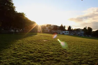 two kites flying in a field with the sun in the background at 2BDR Stylish Comfort Parkside in Vancouver