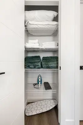 a walk in closet with a bed and towels at Aspen - Town House with 2 Bedrooms, Garage Parking, AC & More! in Calgary