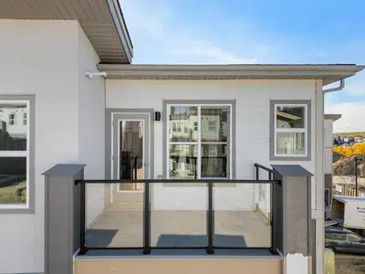 a home with a balcony with glass railings at Aspen - Town House with 2 Bedrooms, Garage Parking, AC & More! in Calgary