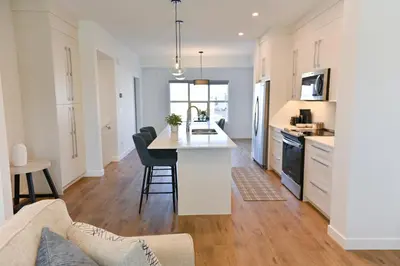 a kitchen and living room with a table and a couch at Luxury 3 Bdrm 3 Bath townhome in Chestermere in Chestermere
