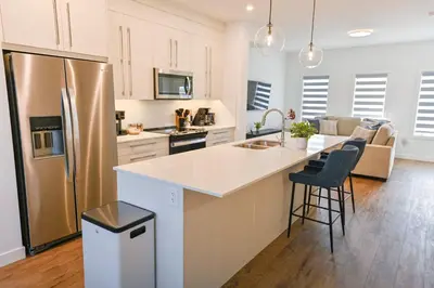 a kitchen with a stainless steel refrigerator and a counter at Luxury 3 Bdrm 3 Bath townhome in Chestermere in Chestermere