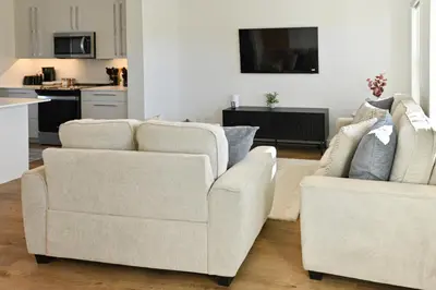 two chairs and a couch in a living room at Luxury 3 Bdrm 3 Bath townhome in Chestermere in Chestermere