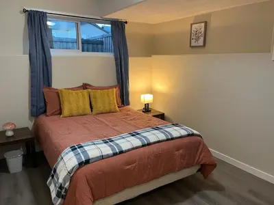 a small bedroom with a bed with a window at Park View Paradise - Big, Bright, Modern, Fully Stocked in Grande Prairie