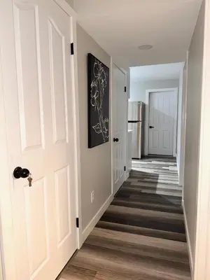 a hallway of a home with a white door at Modern 2 bedroom suite in Calgary