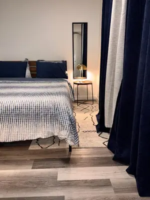 a bedroom with a bed and a table with a mirror at Modern 2 bedroom suite in Calgary
