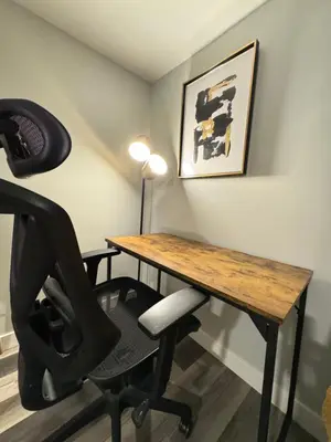 a room with a desk with a chair and a table and a lamp at Modern 2 bedroom suite in Calgary