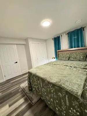 a bedroom with a bed and blue curtains at Modern 2 bedroom suite in Calgary