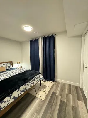 a bedroom with a bed and blue curtains at Modern 2 bedroom suite in Calgary