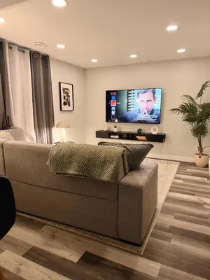 a living room with a couch and a flat screen tv at Modern 2 bedroom suite in Calgary