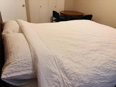 a bed with a white blanket on top of it at Cozy 2 Bedroom Condo with Parking in Calgary