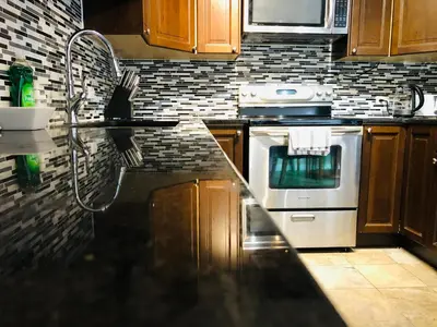 a kitchen with a stove and a counter top at Cozy 2 Bedroom Condo with Parking in Calgary