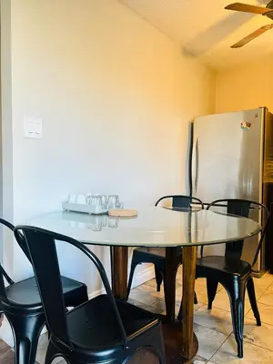 a dining room table with chairs and a refrigerator at Cozy 2 Bedroom Condo with Parking in Calgary
