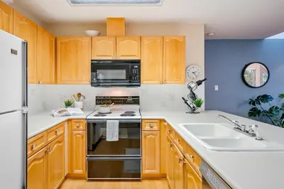 a kitchen with wooden cabinets and a stove and a sink at 31 GlenEagle in Whistler