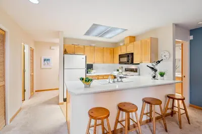 a kitchen with wooden cabinets and a white refrigerator at 31 GlenEagle in Whistler