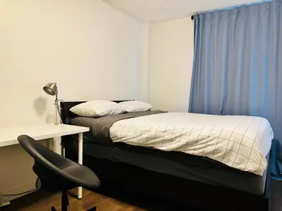 a bedroom with a bed and a desk and a chair at 7th Floor 1 Bedroom Condo with Parking in Calgary