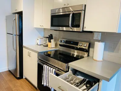 a kitchen with a stove and a microwave at 7th Floor 1 Bedroom Condo with Parking in Calgary