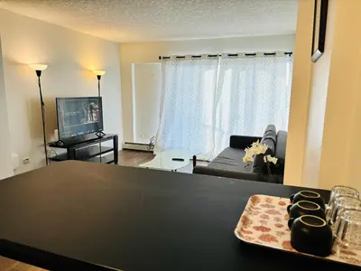 a living room with a black table and a couch at 7th Floor 1 Bedroom Condo with Parking in Calgary