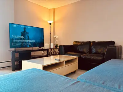 a living room with a couch and a television at 6th Floor 2 Bedroom Condo with Parking in Calgary