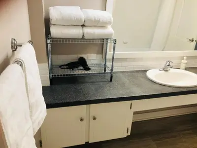 a bathroom with a sink and towels on a counter at 6th Floor 2 Bedroom Condo with Parking in Calgary