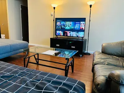 a living room with a couch and a tv at 5th Floor Cozy 1 Bedroom Condo with Parking in Calgary