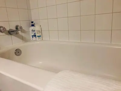 a bath tub with two bottles of detergent on it at 5th Floor Cozy 1 Bedroom Condo with Parking in Calgary