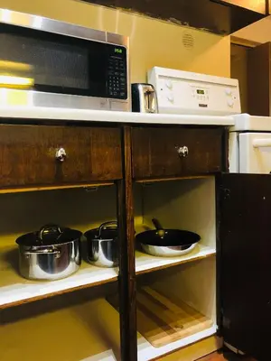 a kitchen with a microwave and pots and pans at 5th Floor Cozy 1 Bedroom Condo with Parking in Calgary