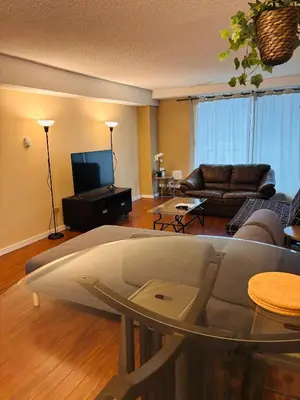 a living room with a couch and a tv at 5th Floor Cozy 1 Bedroom Condo with Parking in Calgary