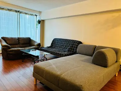 a living room with a couch and a table at 5th Floor Cozy 1 Bedroom Condo with Parking in Calgary