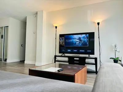 a living room with a flat screen tv and a couch at Cozy 1 Bedroom Condo with Parking in Calgary